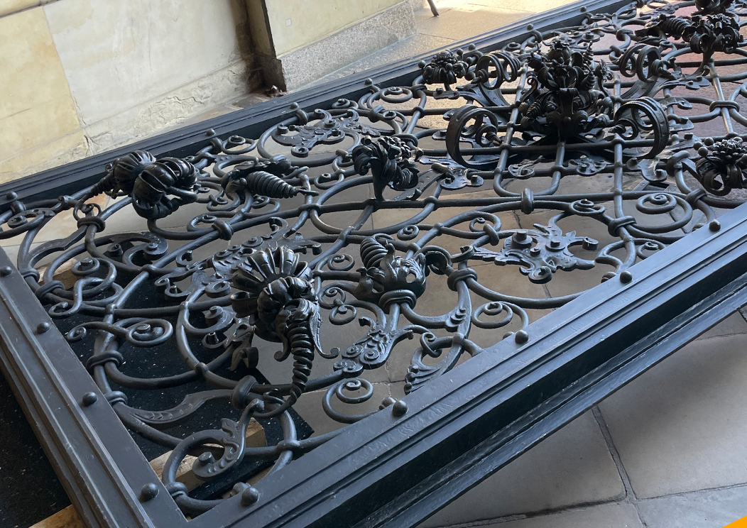 Ein aufwenig verziertes Tor aus Metall mit Blumen und geschwungenen Ornamenten.